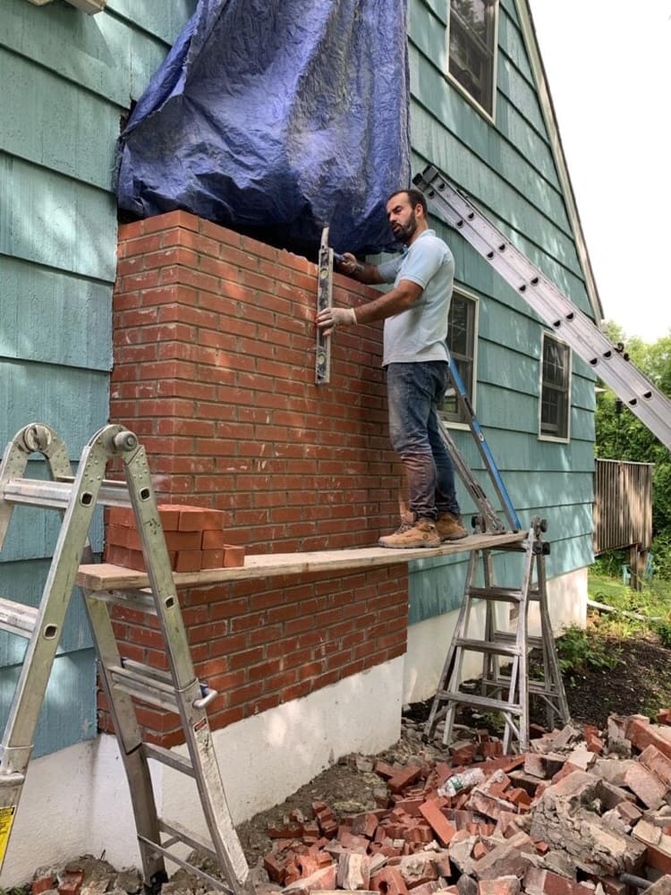 Brick chimney rebuild in progress with new courses laid