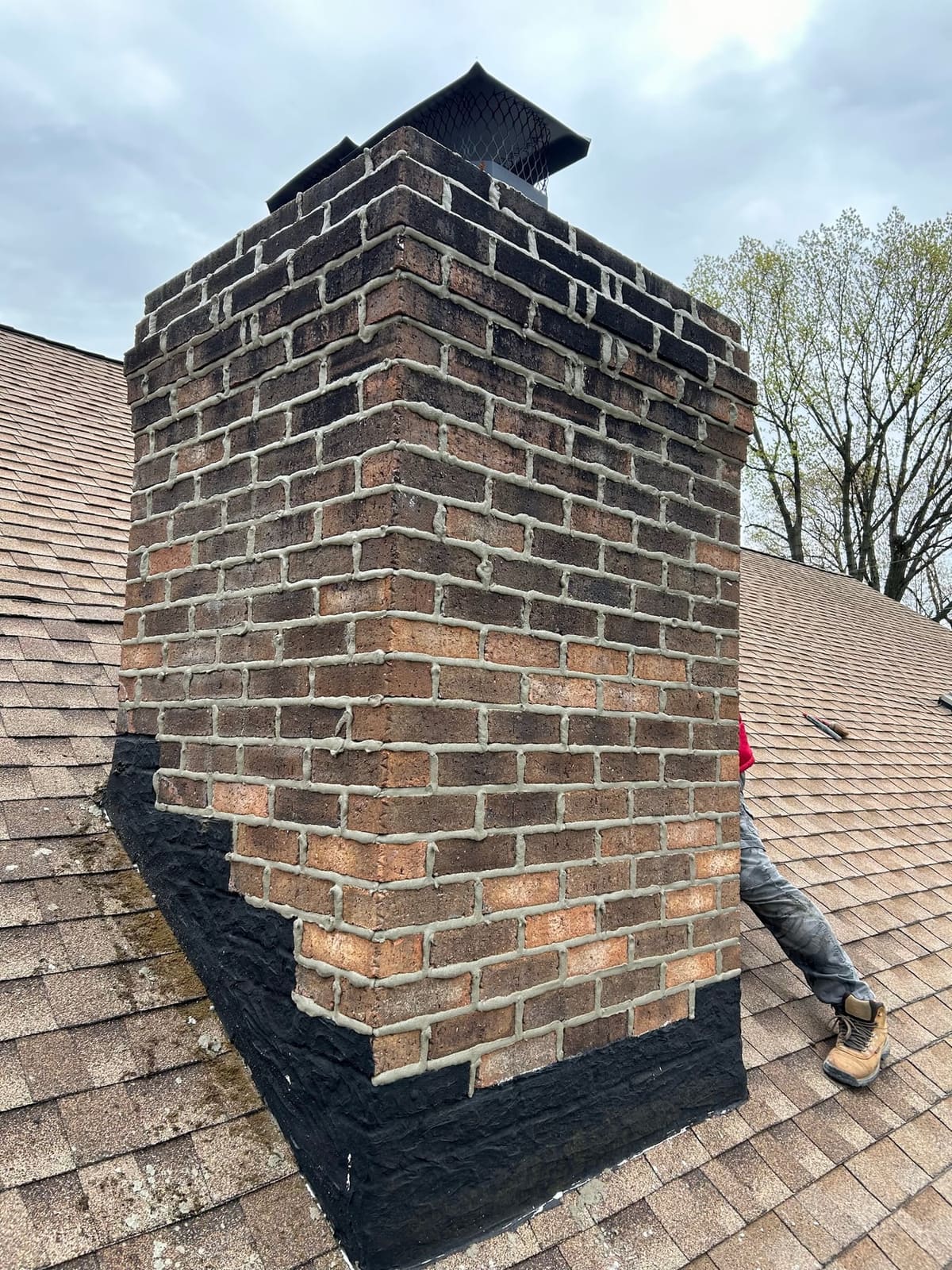 Chimney base flashing sealed on a shingle roof