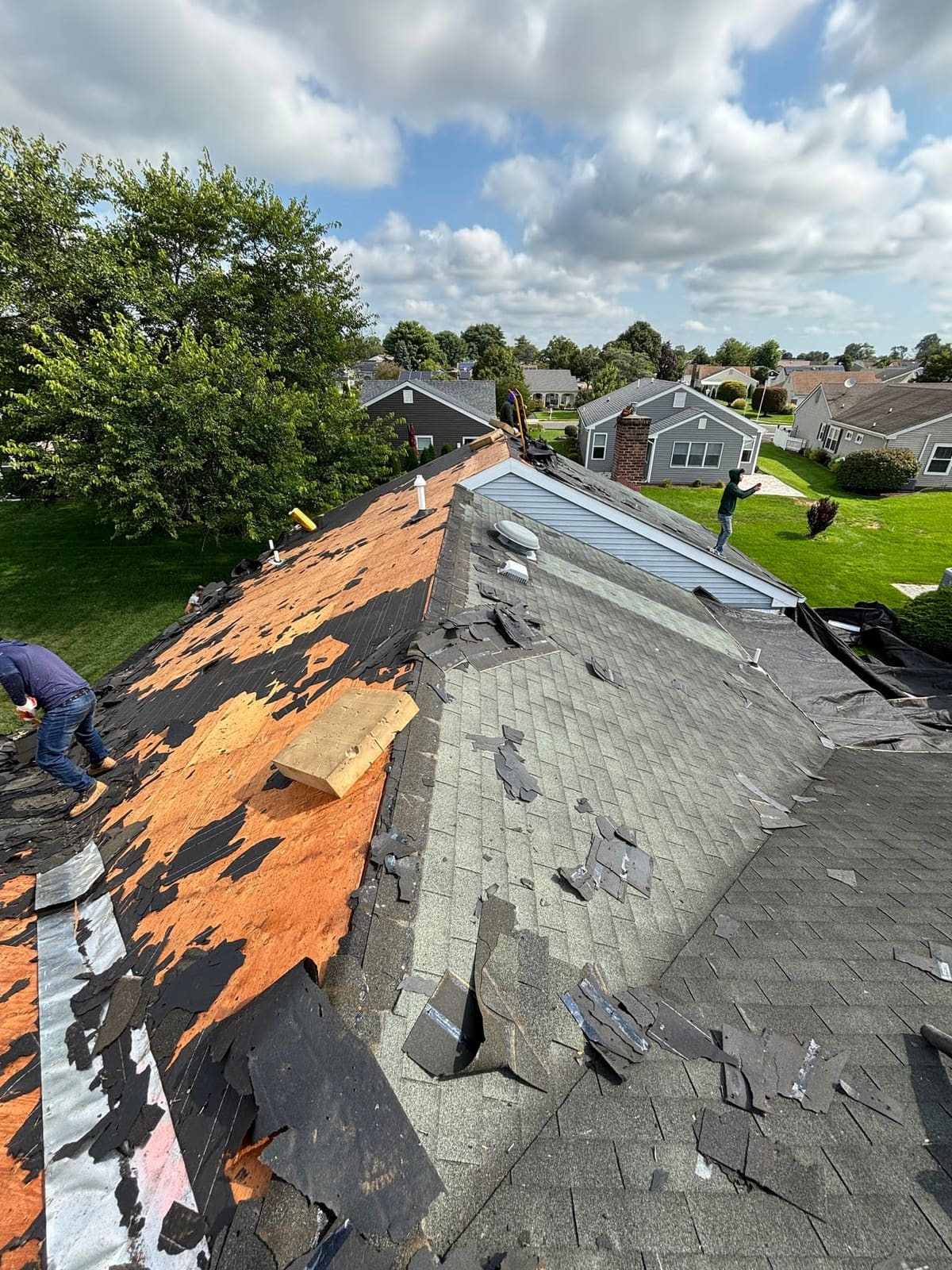 Old shingles removed and decking exposed on a hip roof