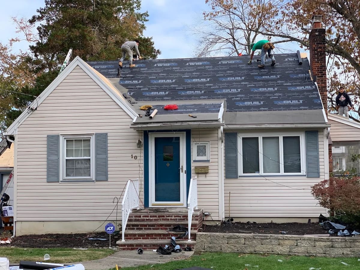 Asset crew installing underlayment on a Cape Cod roof