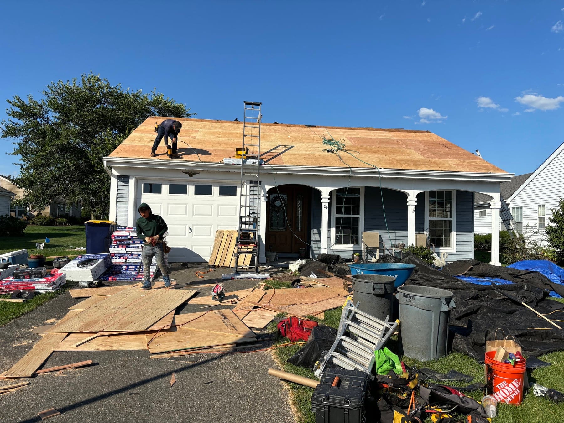 Roof replacement on a ranch home with attached garage, decking exposed